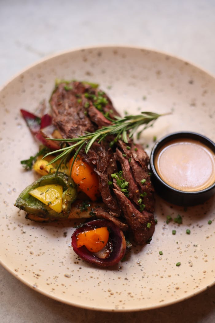 Juicy grilled steak served with roasted vegetables and a rich dipping sauce.